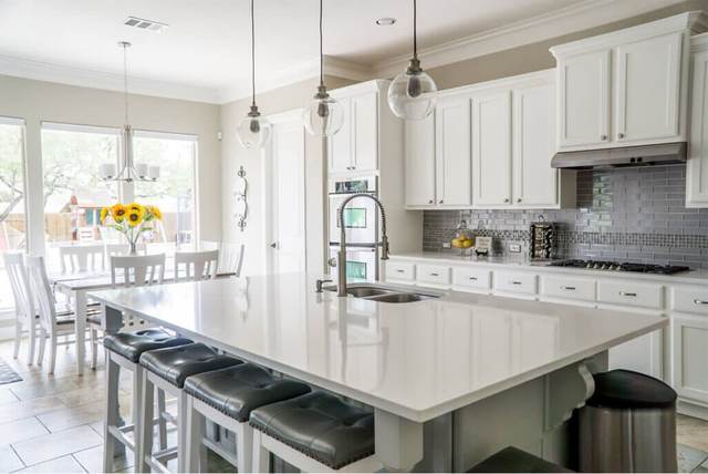 Bright white kitchen with an island and bar stools