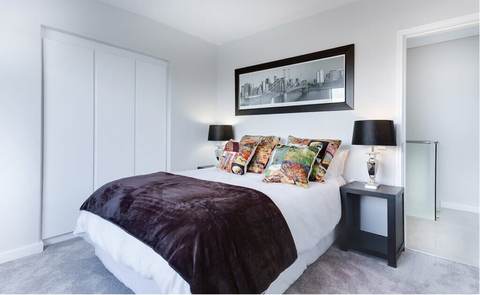 Bedroom with a hotel-style made bed and fresh linens